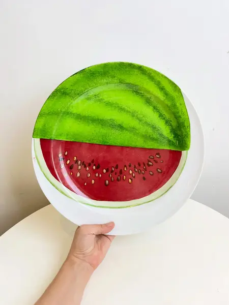 Foto de um(a) ​Grande prato em porcelana pintada a mão e assinado, da categoria de Pratos Decorativos. Grande prato em porcelana pintada a mão e assinado. Leves marcas do tempo e uso. Medidas: 33cm diâmetro. Mostrado de uma perspectiva diferente. Vendido no marketplace Trésors.