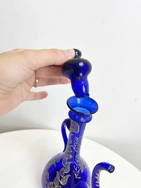 Foto de um(a) ​Jarra oriental em vidro azul, da categoria de Garrafas, potes e jarros. Jarra oriental em vidro azul, pintada a mão. Mínimas marcas do tempo e uso. Medidas: 25x11cm. Mostrado de uma perspectiva diferente. Vendido no marketplace Trésors.