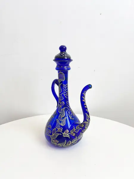 Foto de um(a) ​Jarra oriental em vidro azul, da categoria de Garrafas, potes e jarros. Jarra oriental em vidro azul, pintada a mão. Mínimas marcas do tempo e uso. Medidas: 25x11cm. Mostrado de uma perspectiva diferente. Vendido no marketplace Trésors.