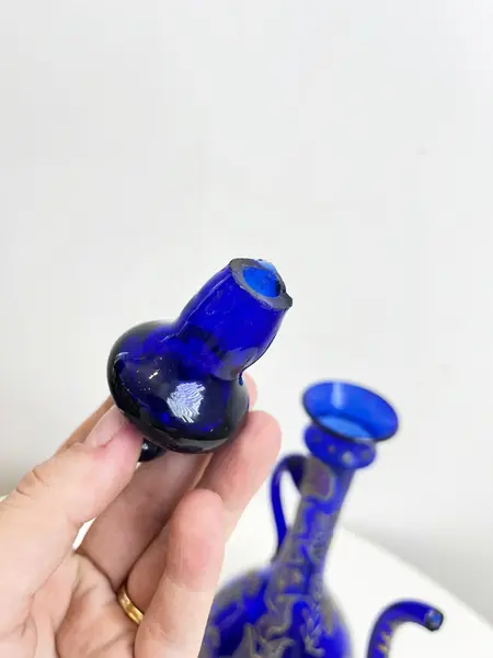 Foto de um(a) ​Jarra oriental em vidro azul, da categoria de Garrafas, potes e jarros. Jarra oriental em vidro azul, pintada a mão. Mínimas marcas do tempo e uso. Medidas: 25x11cm. Mostrado de uma perspectiva diferente. Vendido no marketplace Trésors.