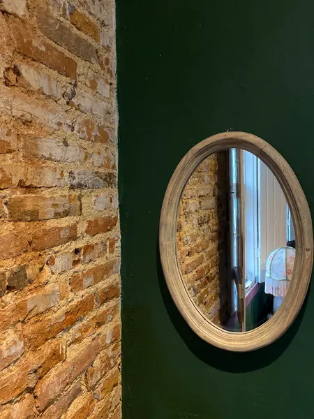 Foto de um(a) Espelho Natural, da categoria de Espelhos. Moldura em madeira nobre, acabamento suave e formato oval. Mostrado de uma perspectiva diferente. Vendido no marketplace Trésors.