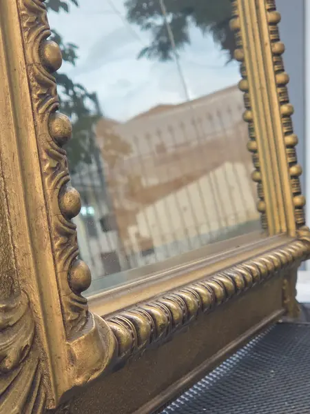 Foto de um(a) Espelho Antigo Dourado em Madeira com Vidro Bisotê, da categoria de Espelhos. Espelho antigo com moldura em madeira, acabamento dourado e detalhes entalhados. Possui vidro bisotê, que valoriza o... Mostrado de uma perspectiva diferente. Vendido no marketplace Trésors.