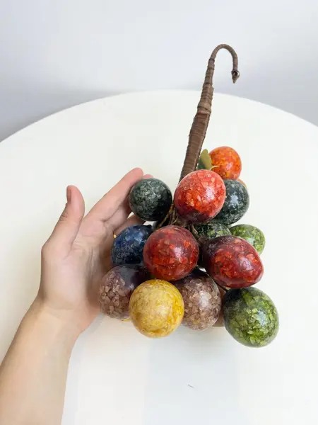 Foto de um(a) ​Grande cacho de frutas em resina e metal para pendurar, da categoria de Objetos decorativos. Grande cacho de frutas em resina e metal para pendurar. Possui marcas do tempo e uso como nas fotos. Medidas: 34x15cm. Mostrado de uma perspectiva diferente. Vendido no marketplace Trésors.