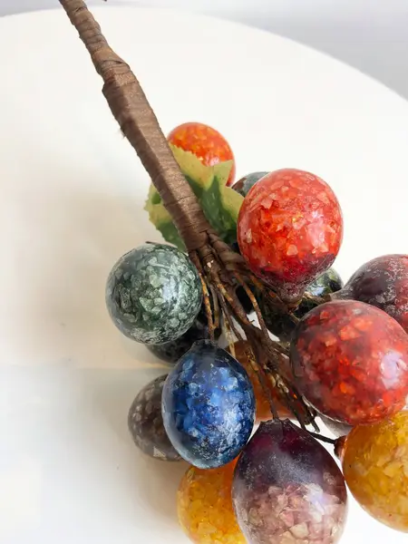 Foto de um(a) ​Grande cacho de frutas em resina e metal para pendurar, da categoria de Objetos decorativos. Grande cacho de frutas em resina e metal para pendurar. Possui marcas do tempo e uso como nas fotos. Medidas: 34x15cm. Mostrado de uma perspectiva diferente. Vendido no marketplace Trésors.