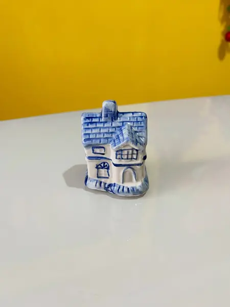 Foto de um(a) ​Enfeite casinha azul e branca em porcelana, da categoria de Objetos decorativos. Casinha em porcelana. Perfeito estado. Medidas: 5x4x6cm. Mostrado de uma perspectiva diferente. Vendido no marketplace Trésors.