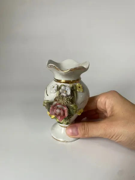 Foto de um(a) Pequeno vaso em porcelana, da categoria de Vasos. Vasinho em porcelana com flores em alto-relevo. Mede: 10 x 6cm. Mostrado de uma perspectiva diferente. Vendido no marketplace Trésors.