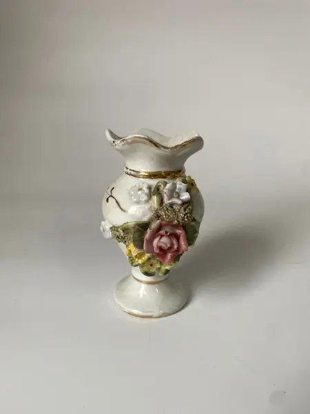 Foto de um(a) Pequeno vaso em porcelana, da categoria de Vasos. Vasinho em porcelana com flores em alto-relevo. Mede: 10 x 6cm. Mostrado de uma perspectiva diferente. Vendido no marketplace Trésors.