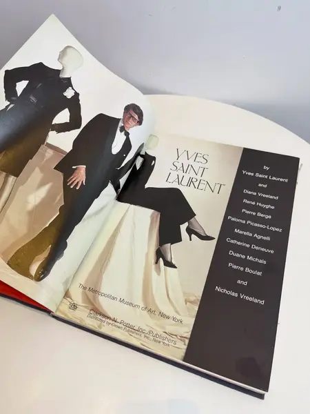 Foto de um(a) Livro capa dura Yves Saint Laurent 1983, da categoria de Livros. Maravilhoso livro capa dura em tecido, em inglês, de 1983. Marcas do tempo e uso. Mostrado de uma perspectiva diferente. Vendido no marketplace Trésors.