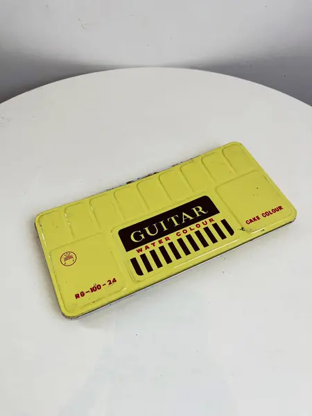 Foto de um(a) ​Antigo estojo de aquarela com 24 cores da marca Guitar - anos 60/70, da categoria de Outros colecionáveis. Antigo estojo de aquarela com 24 cores da marca Guitar, da década de 60/70. Marcas do tempo e uso como nas fotos. Mostrado de uma perspectiva diferente. Vendido no marketplace Trésors.