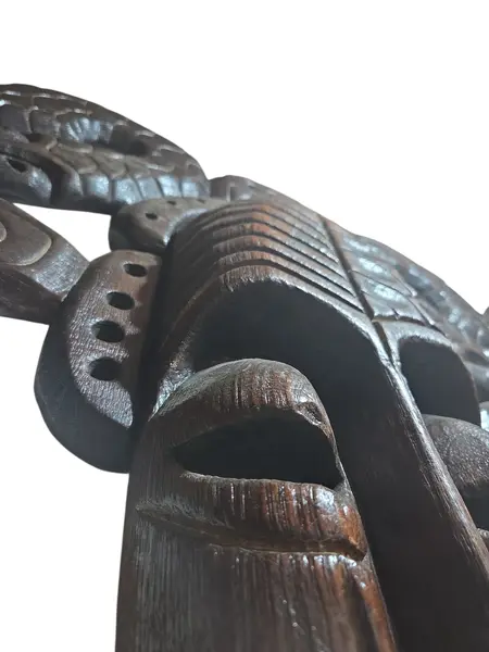 Foto de um(a) Máscara Tribal Decorativa em Madeira Nobre – Entalhe de Serpentes e Simbolismo Africano, da categoria de Objetos de parede esculturais. Esta é uma peça de arte mural imponente e sofisticada, perfeita para colecionadores ou para quem deseja um ponto focal... Mostrado de uma perspectiva diferente. Vendido no marketplace Trésors.