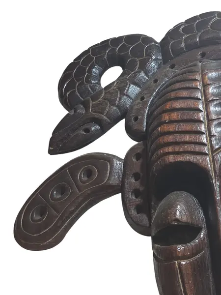 Foto de um(a) Máscara Tribal Decorativa em Madeira Nobre – Entalhe de Serpentes e Simbolismo Africano, da categoria de Objetos de parede esculturais. Esta é uma peça de arte mural imponente e sofisticada, perfeita para colecionadores ou para quem deseja um ponto focal... Mostrado de uma perspectiva diferente. Vendido no marketplace Trésors.