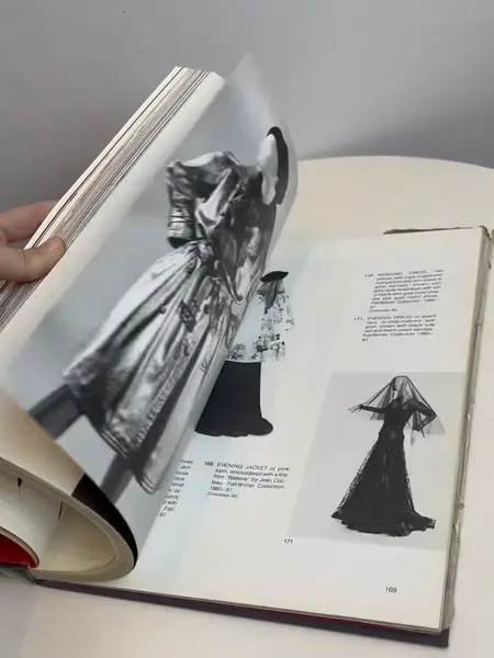 Foto de um(a) Livro capa dura Yves Saint Laurent 1983, da categoria de Livros. Maravilhoso livro capa dura em tecido, em inglês, de 1983. Marcas do tempo e uso. Mostrado de uma perspectiva diferente. Vendido no marketplace Trésors.
