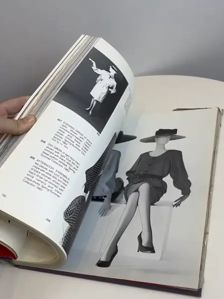 Foto de um(a) Livro capa dura Yves Saint Laurent 1983, da categoria de Livros. Maravilhoso livro capa dura em tecido, em inglês, de 1983. Marcas do tempo e uso. Mostrado de uma perspectiva diferente. Vendido no marketplace Trésors.