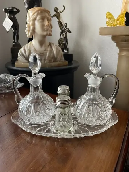 Foto de um(a) Antigo Galheteiro Saleiro Em Cristal Francês, da categoria de Saleiros e pimenteiros. Antigo galheteiro em cristal francês prensado. Composto por cinco peças. **Uma das garrafinhas tem um lascado na borda.... Mostrado de uma perspectiva diferente. Vendido no marketplace Trésors.