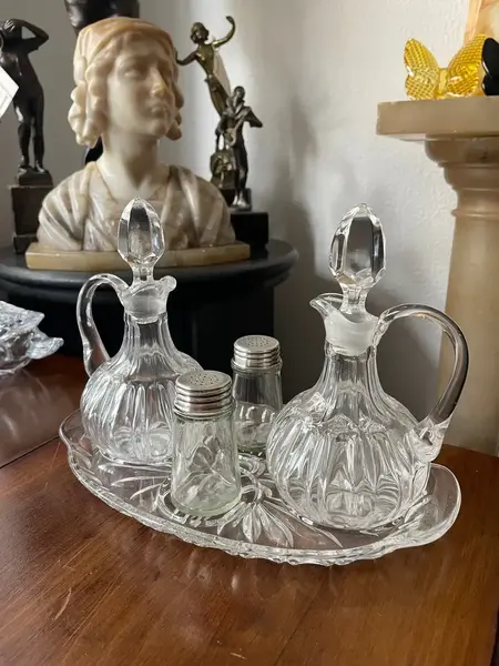 Foto de um(a) Antigo Galheteiro Saleiro Em Cristal Francês, da categoria de Saleiros e pimenteiros. Antigo galheteiro em cristal francês prensado. Composto por cinco peças. **Uma das garrafinhas tem um lascado na borda.... Mostrado de uma perspectiva diferente. Vendido no marketplace Trésors.