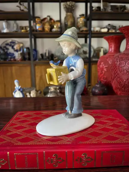 Foto de um(a) Antigo Bibelô Figurine De Menino Com Pássaro Porcelana Alemã, da categoria de Escultura. Antiga figurine/bibelô em porcelana artística alemã. Cores típicas de meados do século XX. Muito decorativa e colecionável.... Mostrado de uma perspectiva diferente. Vendido no marketplace Trésors.