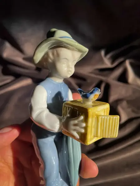 Foto de um(a) Antigo Bibelô Figurine De Menino Com Pássaro Porcelana Alemã, da categoria de Escultura. Antiga figurine/bibelô em porcelana artística alemã. Cores típicas de meados do século XX. Muito decorativa e colecionável.... Mostrado de uma perspectiva diferente. Vendido no marketplace Trésors.
