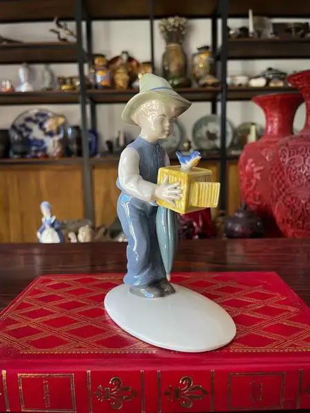 Foto de um(a) Antigo Bibelô Figurine De Menino Com Pássaro Porcelana Alemã, da categoria de Escultura. Antiga figurine/bibelô em porcelana artística alemã. Cores típicas de meados do século XX. Muito decorativa e colecionável.... Mostrado de uma perspectiva diferente. Vendido no marketplace Trésors.