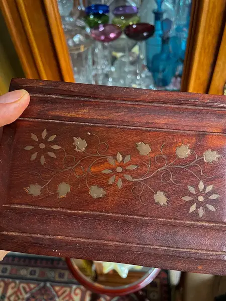 Foto de um(a) Antiga Caixa Decorativa Cigarreira Em Madeira E Bronze, da categoria de Cigarreiras e piteiras. Antiga caixa decorativa ou cigarreira artística em madeira com a tampa com decoração floral em bronze.Medidas 4 x 15 x 11cm. Mostrado de uma perspectiva diferente. Vendido no marketplace Trésors.