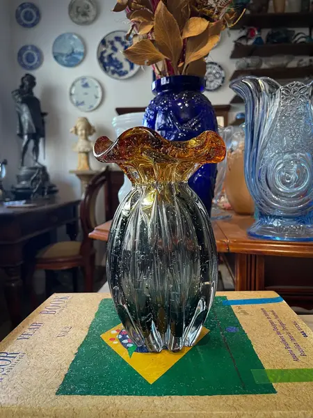Foto de um(a) Antigo Vaso Jarro Art Deco Murano Italy Glass Âmbar, da categoria de Vasos. ~ Italy Glass ~Antigo vaso em Murano na cor grafite com âmbar. Essa combinação de cores foi um grande acerto! Corpo gomado... Mostrado de uma perspectiva diferente. Vendido no marketplace Trésors.