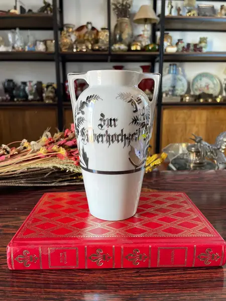Foto de um(a) Antigo Vasinho Art Deco Em Porcelana Alemã Pintado Prata, da categoria de Vasos. Antigo e lindo vasinho em porcelana alemã. Pintado à mão com prata de lei Período Art DecoMedidas 16x10cmBocal 6cm. Mostrado de uma perspectiva diferente. Vendido no marketplace Trésors.