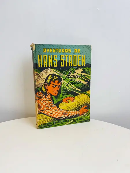 Foto de um(a) ​Livro capa dura As Aventuras de Hans Staden - Monteiro Lobato 1957, da categoria de Livros. Livro capa dura As Aventuras de Hans Staden, narrado por Dona Benta, de Monteiro Lobato, de 1957. Marcas do tempo e uso como... Mostrado de uma perspectiva diferente. Vendido no marketplace Trésors.