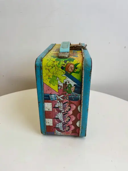 Foto de um(a) ​Antiga e rara lancheira da Disney, de 1979 em metal, da categoria de Outros colecionáveis. Antiga e rara lancheira da Disney, de 1979. Em metal estampado. Com marcas do tempo e uso como nas fotos. Medidas: 20x19cm. Mostrado de uma perspectiva diferente. Vendido no marketplace Trésors.
