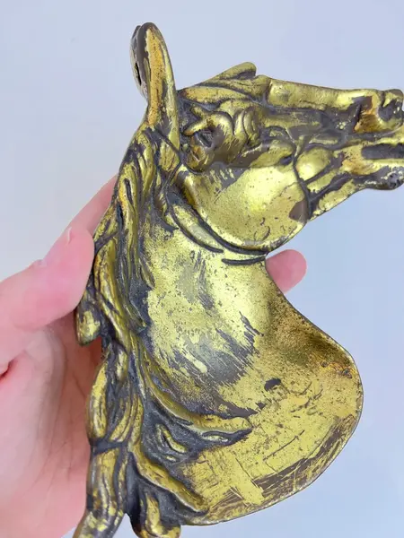 Foto de um(a) Cinzeiro em metal formato cavalo, da categoria de Cinzeiros. Cinzeiro em metal amarelo em formato de cavalo, com marcas do tempo e uso. Medidas: 16x20cm. Mostrado de uma perspectiva diferente. Vendido no marketplace Trésors.