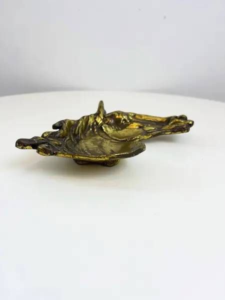 Foto de um(a) Cinzeiro em metal formato cavalo, da categoria de Cinzeiros. Cinzeiro em metal amarelo em formato de cavalo, com marcas do tempo e uso. Medidas: 16x20cm. Mostrado de uma perspectiva diferente. Vendido no marketplace Trésors.