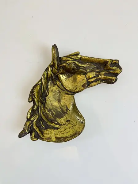 Foto de um(a) Cinzeiro em metal formato cavalo, da categoria de Cinzeiros. Cinzeiro em metal amarelo em formato de cavalo, com marcas do tempo e uso. Medidas: 16x20cm. Mostrado de uma perspectiva diferente. Vendido no marketplace Trésors.