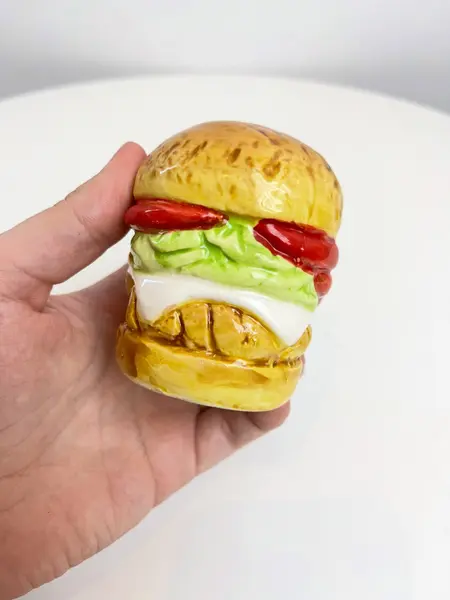 Foto de um(a) Saleiro em cerâmica formato hamburguer, da categoria de Saleiros e pimenteiros. Saleiro em cerâmica com tampa na base em silicone. Perfeito estado. Medidas: 7x5cm. Mostrado de uma perspectiva diferente. Vendido no marketplace Trésors.