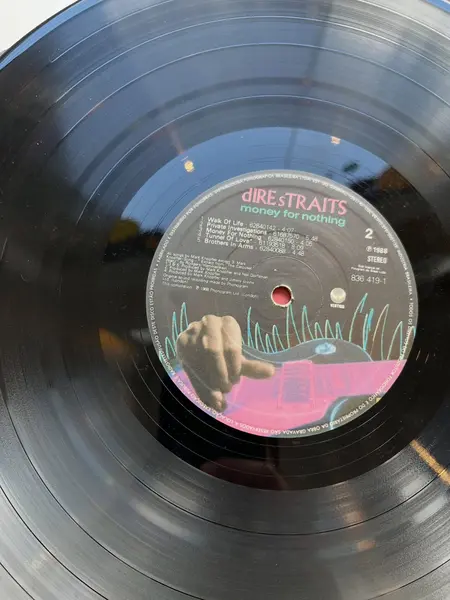 Foto de um(a) ​LP Money For Nothing - Dire Straits 1988, da categoria de LPs ou Discos de Vinil. LP Money For Nothing, Dire Straits, de 1988. Disco em perfeito estado. Mostrado de uma perspectiva diferente. Vendido no marketplace Trésors.