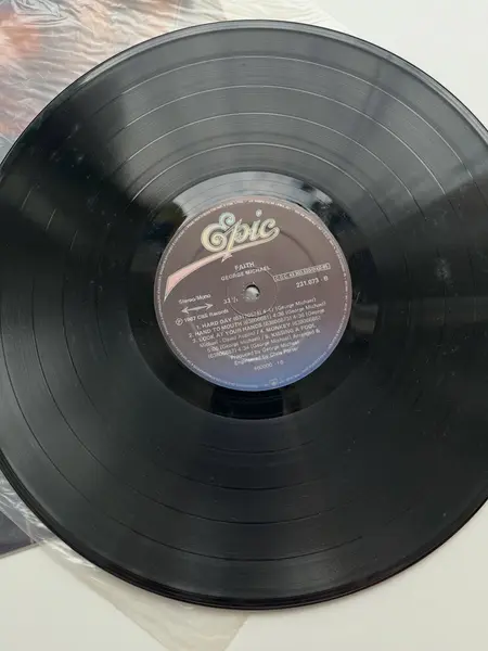 Foto de um(a) ​LP Faith - George Michael 1987, da categoria de LPs ou Discos de Vinil . LP Faith, George Michael, de 1987. Perfeito estado. Mostrado de uma perspectiva diferente. Vendido no marketplace Trésors.