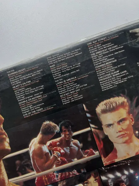 Foto de um(a) ​LP Trilha sonora original de Rocky IV -1982, da categoria de LPs ou Discos de Vinil . LP com a trilha sonora original de Rocky IV, de 1982. Dois mínimos riscos superficiais. Mostrado de uma perspectiva diferente. Vendido no marketplace Trésors.