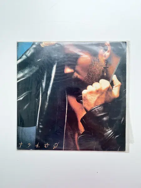 Foto de um(a) ​LP Faith - George Michael 1987, da categoria de LPs ou Discos de Vinil . LP Faith, George Michael, de 1987. Perfeito estado. Mostrado de uma perspectiva diferente. Vendido no marketplace Trésors.
