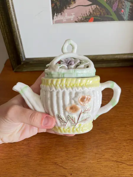 Foto de um(a) ​Pequeno bule em porcelana pintada à mão, da categoria de Bules. Pequeno bule em porcelana pintado a mão. Possui apenas uma folha quebrada, mas é quase imperceptível. Medidas: 14 x 13cm. Mostrado de uma perspectiva diferente. Vendido no marketplace Trésors.