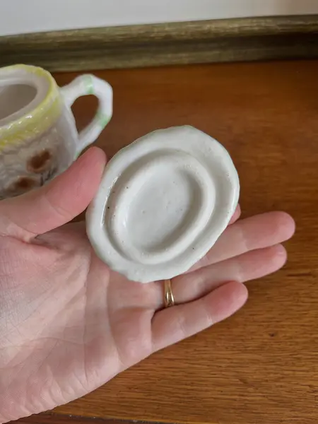 Foto de um(a) ​Pequeno bule em porcelana pintada à mão, da categoria de Bules. Pequeno bule em porcelana pintado a mão. Possui apenas uma folha quebrada, mas é quase imperceptível. Medidas: 14 x 13cm. Mostrado de uma perspectiva diferente. Vendido no marketplace Trésors.
