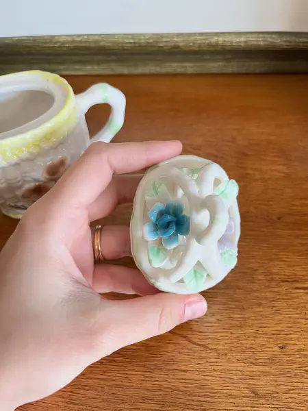 Foto de um(a) ​Pequeno bule em porcelana pintada à mão, da categoria de Bules. Pequeno bule em porcelana pintado a mão. Possui apenas uma folha quebrada, mas é quase imperceptível. Medidas: 14 x 13cm. Mostrado de uma perspectiva diferente. Vendido no marketplace Trésors.
