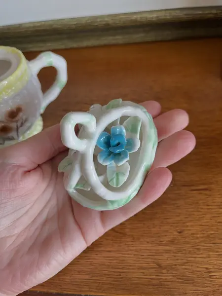 Foto de um(a) ​Pequeno bule em porcelana pintada à mão, da categoria de Bules. Pequeno bule em porcelana pintado a mão. Possui apenas uma folha quebrada, mas é quase imperceptível. Medidas: 14 x 13cm. Mostrado de uma perspectiva diferente. Vendido no marketplace Trésors.