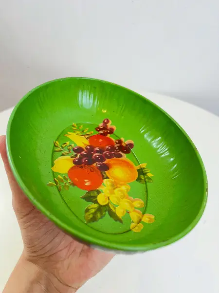 Foto de um(a) ​ Pequena travessa em metal da marca Metalma, da categoria de Travessas e tigelas. Pequeno bowl ou petisqueira em metal estampado e esmaltado da marca Metalma. Leves marcas do tempo e uso. Medidas: 18x13x4cm. Mostrado de uma perspectiva diferente. Vendido no marketplace Trésors.