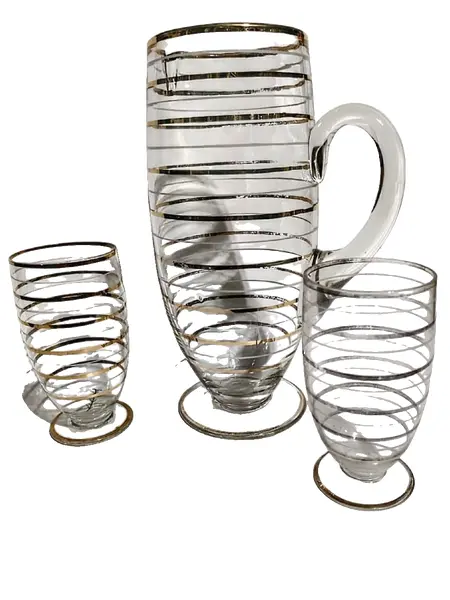 Foto de um(a) Conjunto Jarra e Copos em Vidro e Ouro Anos 50, da categoria de Jogos de taças e copos. Jarra de vidro com filetes em ouro da década de 1950, com dois copos. A: 25,5 cm / Diâmetro: 10 cmCopos: A 13 cm /... Vendido no marketplace Trésors.