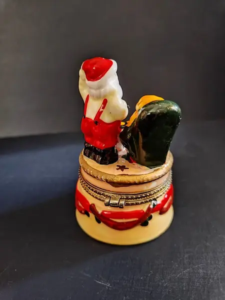 Foto de um(a) Caixinha Porcelana Papai Noel, Década de 2000, da categoria de Cestos e Caixas. Caixa em porcelana policromada com motivo natalino, década de 2000. A: 9,5 cm / Diâmetro: 6 cm peso: 145 g. Mostrado de uma perspectiva diferente. Vendido no marketplace Trésors.