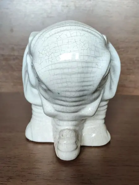 Foto de um(a) Cachepô Elefante Anos 90, da categoria de Cachepot. Cachepô formato de elefante em porcelana craquelada na cor branca, década de 1990. A: 12,5 cm / L: 20cm / P: 12 cmPeso: 704g. Mostrado de uma perspectiva diferente. Vendido no marketplace Trésors.