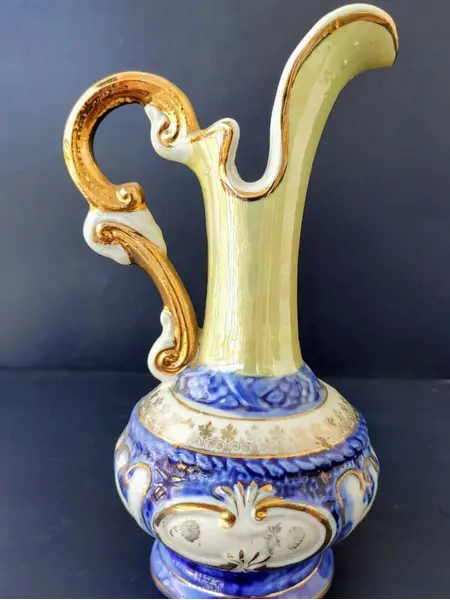 Foto de um(a) Pequena Jarra Blue anos 40, Indústria Brasileira, da categoria de Jarros. Pequena jarra em porcelana com pintura azul cobalto e amarelo perolado, filetada com ouro e grega com trevos também ouro... Mostrado de uma perspectiva diferente. Vendido no marketplace Trésors.