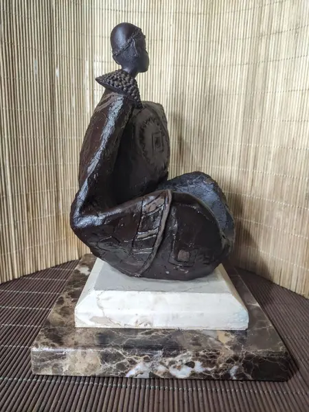 Foto de um(a) Escultura Guerreiro Africano Anos 80, da categoria de Escultura. Escultura de guerreiro africano em resina com pátina marrom envelhecida e base em mármore marrom imperador e travertino.... Mostrado de uma perspectiva diferente. Vendido no marketplace Trésors.