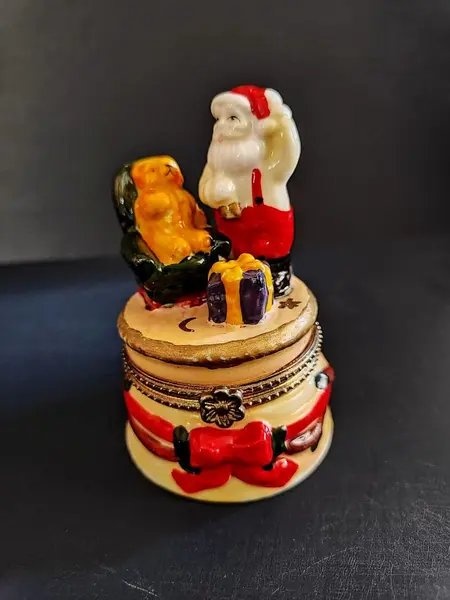 Foto de um(a) Caixinha Porcelana Papai Noel, Década de 2000, da categoria de Cestos e Caixas. Caixa em porcelana policromada com motivo natalino, década de 2000. A: 9,5 cm / Diâmetro: 6 cm peso: 145 g. Mostrado de uma perspectiva diferente. Vendido no marketplace Trésors.