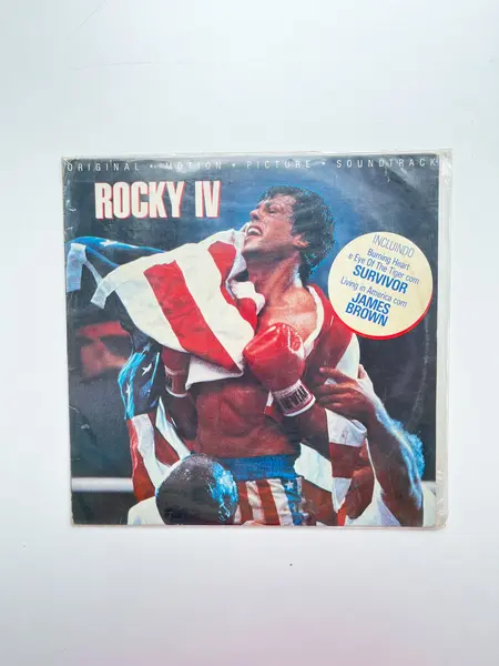 Foto de um(a) ​LP Trilha sonora original de Rocky IV -1982, da categoria de LPs ou Discos de Vinil . LP com a trilha sonora original de Rocky IV, de 1982. Dois mínimos riscos superficiais. Mostrado de uma perspectiva diferente. Vendido no marketplace Trésors.