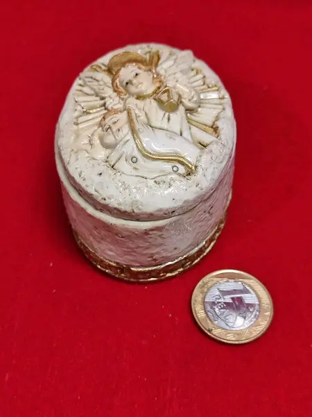 Foto de um(a) Porta Joia Anjo da Guarda em Resina Italiana, Década de 1990, da categoria de Porta-Jóias. Porta jóia oval em resina italiana, parte interna e detalhes em dourado, tampa em relevo com imagem do anjo da guarda,... Mostrado de uma perspectiva diferente. Vendido no marketplace Trésors.