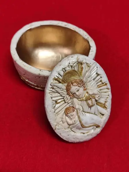 Foto de um(a) Porta Joia Anjo da Guarda em Resina Italiana, Década de 1990, da categoria de Porta-Jóias. Porta jóia oval em resina italiana, parte interna e detalhes em dourado, tampa em relevo com imagem do anjo da guarda,... Mostrado de uma perspectiva diferente. Vendido no marketplace Trésors.