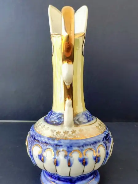 Foto de um(a) Pequena Jarra Blue anos 40, Indústria Brasileira, da categoria de Jarros. Pequena jarra em porcelana com pintura azul cobalto e amarelo perolado, filetada com ouro e grega com trevos também ouro... Mostrado de uma perspectiva diferente. Vendido no marketplace Trésors.